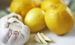 Czosnek, cytryny i ząbki czosnku – składniki na naturalny antybiotyk z czosnku, miodu i cytryny.