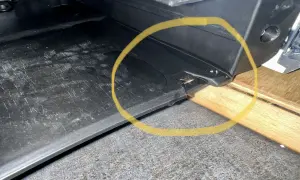 Widoczny wyciek wody spod ekspresu Saeco. Woda gromadzi się na czarnej tacce ociekowej, tworząc kałużę.